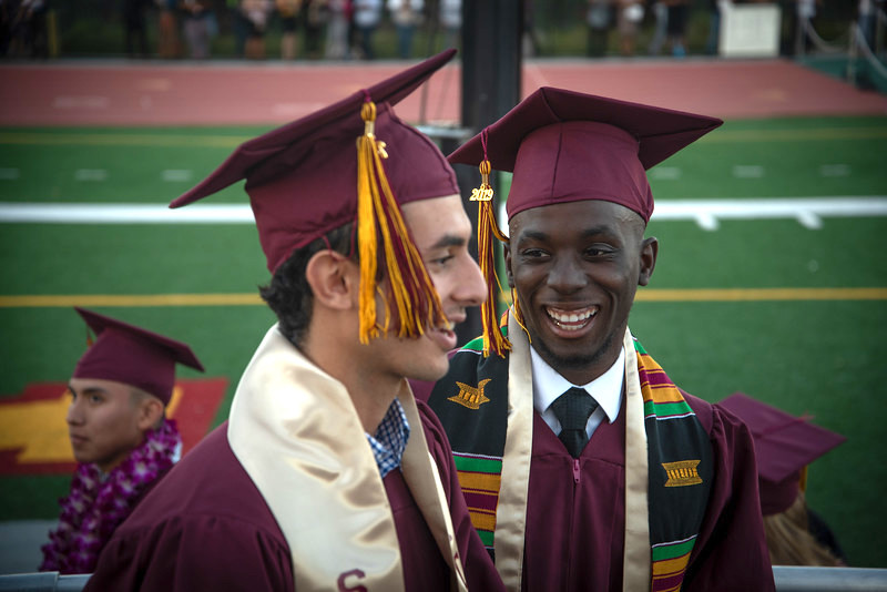 two young men at graduation, in caps and gowns