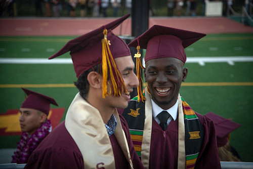 two graduates smiling