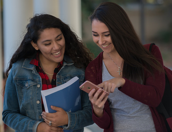 two students looking at smartphone