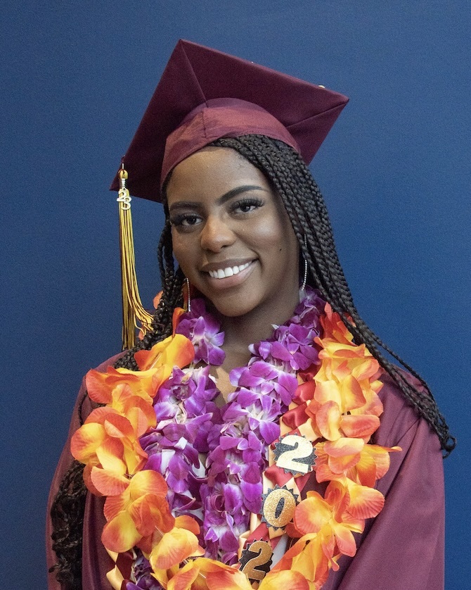 young woman in grad cap with flower leis