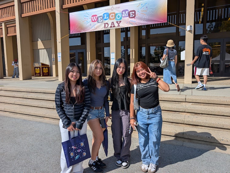 students waving under Welcome Day sign